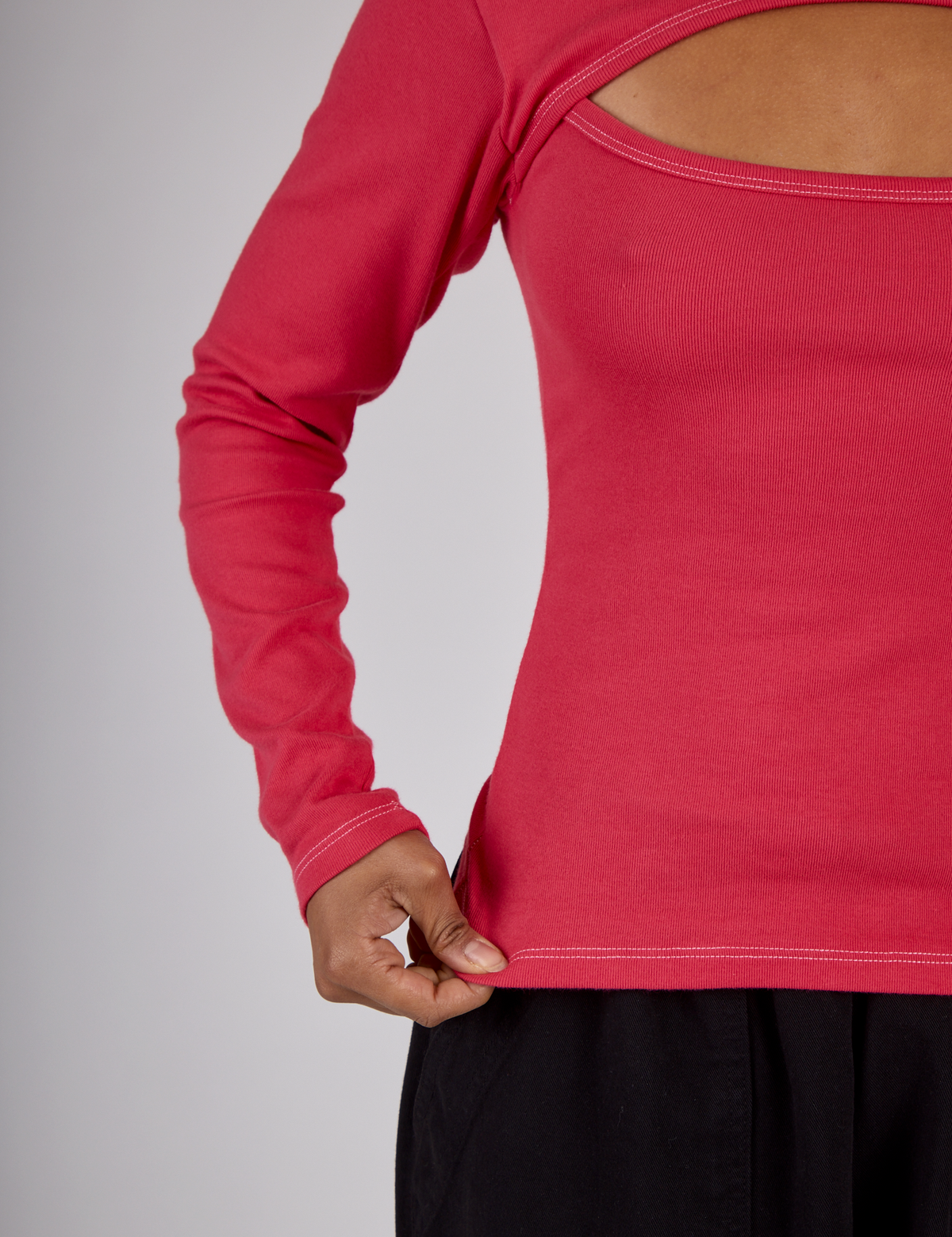 Close up of the hem on the Hot Pink Long Sleeve Porthole Tee worn by Mika