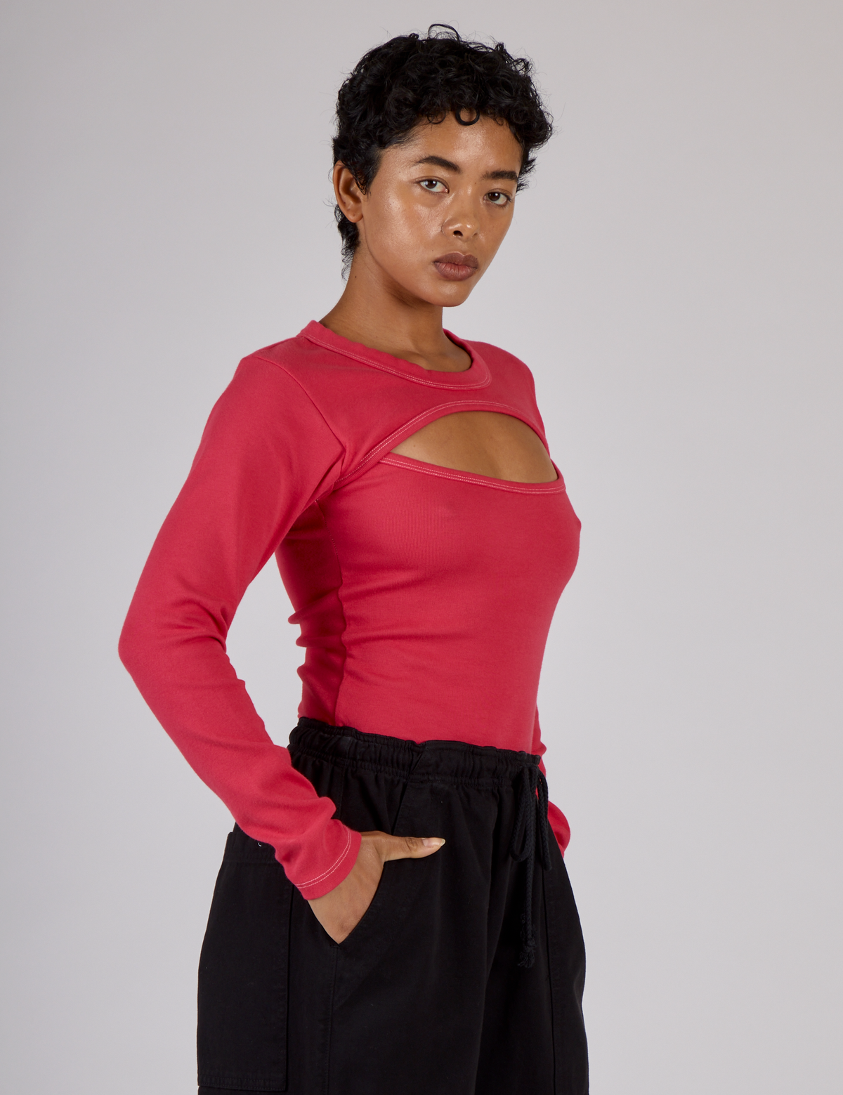 Angled side view of the Hot Pink Long Sleeve Porthole Tee on Mika
