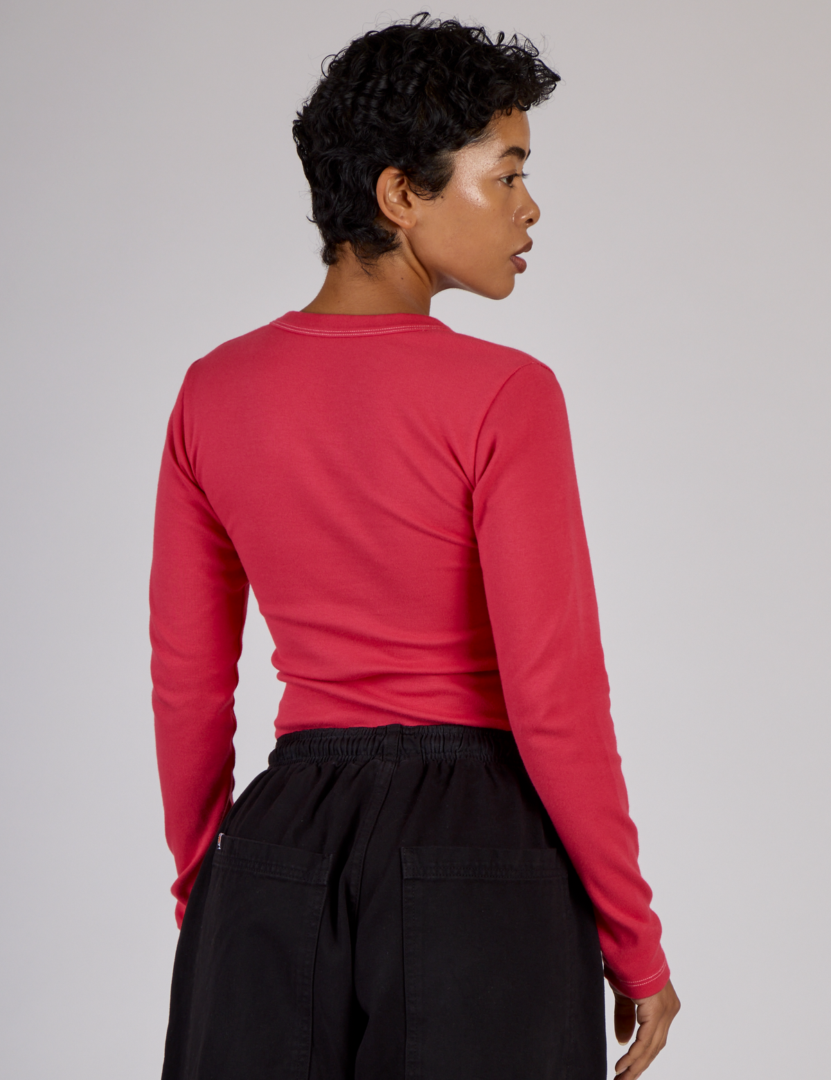Angled back view of the Hot Pink Long Sleeve Porthole Tee on Mika