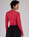 Angled back view of the Hot Pink Long Sleeve Porthole Tee on Mika