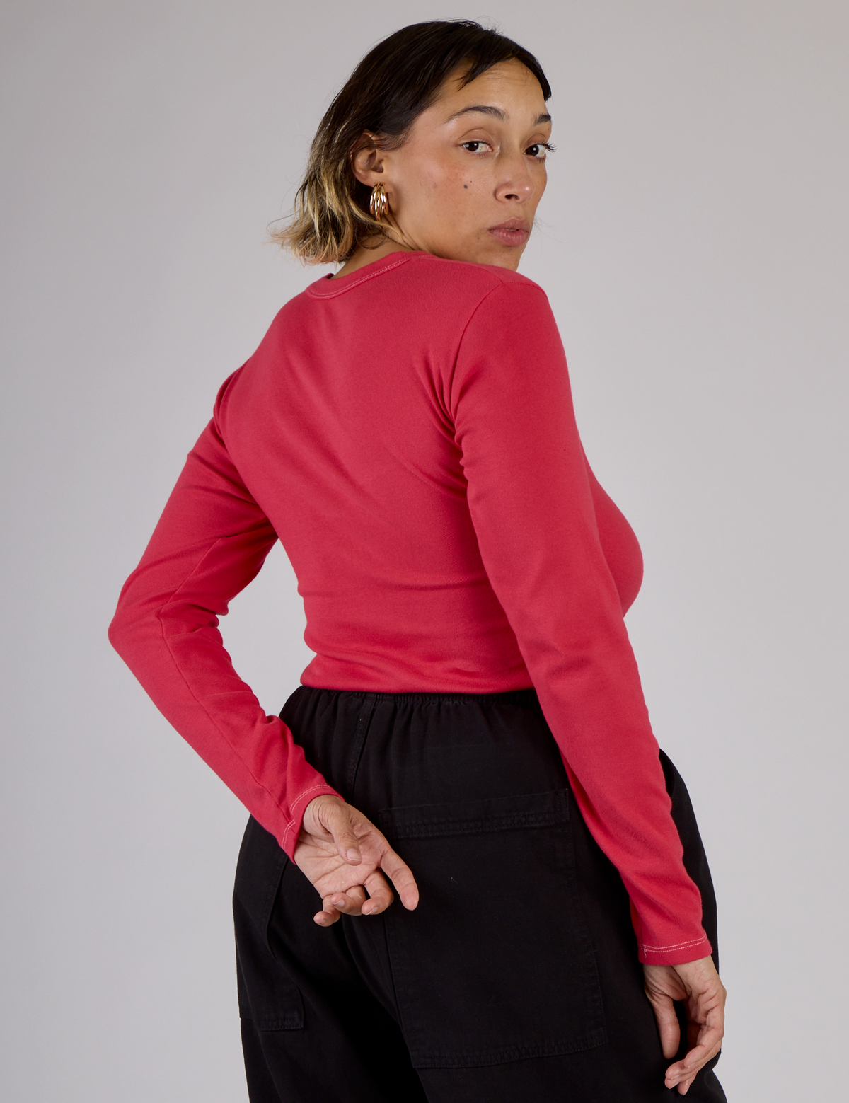 Angled back view of Tiara in the Hot Pink Long Sleeve Porthole Tee