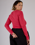 Angled back view of Tiara in the Hot Pink Long Sleeve Porthole Tee