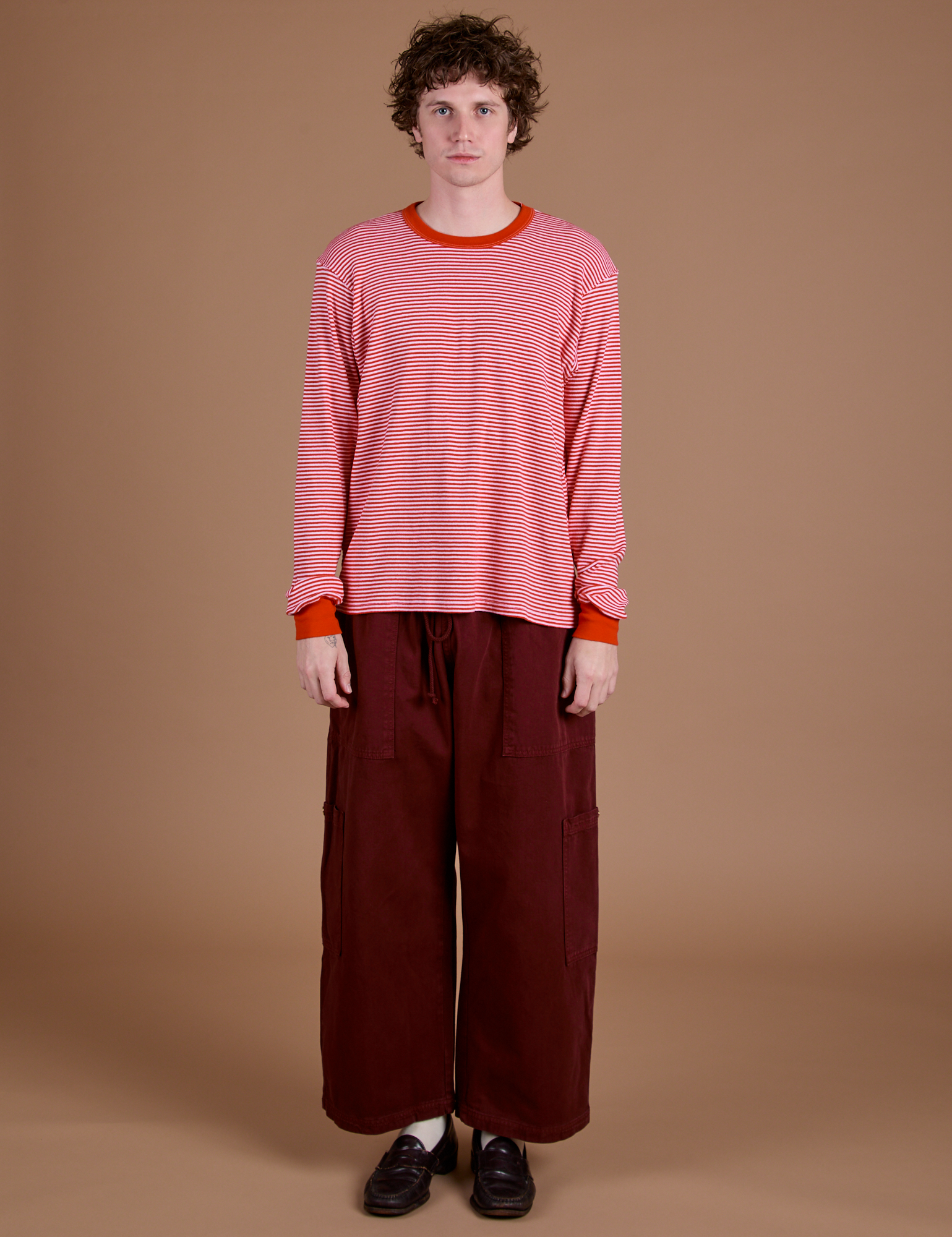 Quinn is 6’3” and wearing XS Long Sleeve Burly Tee in Red/White Stripe paired with red wine Drop Pocket Cargo Pants