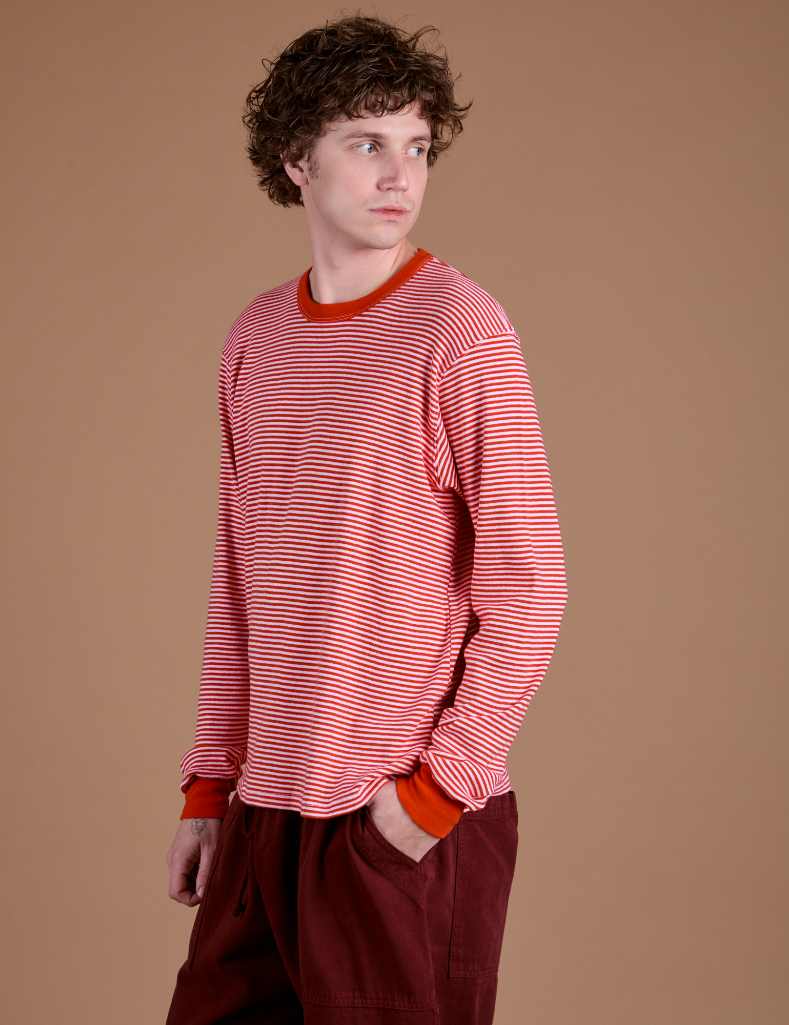 Angled front view of Long Sleeve Burly Tee in Red/White Stripe on Quinn