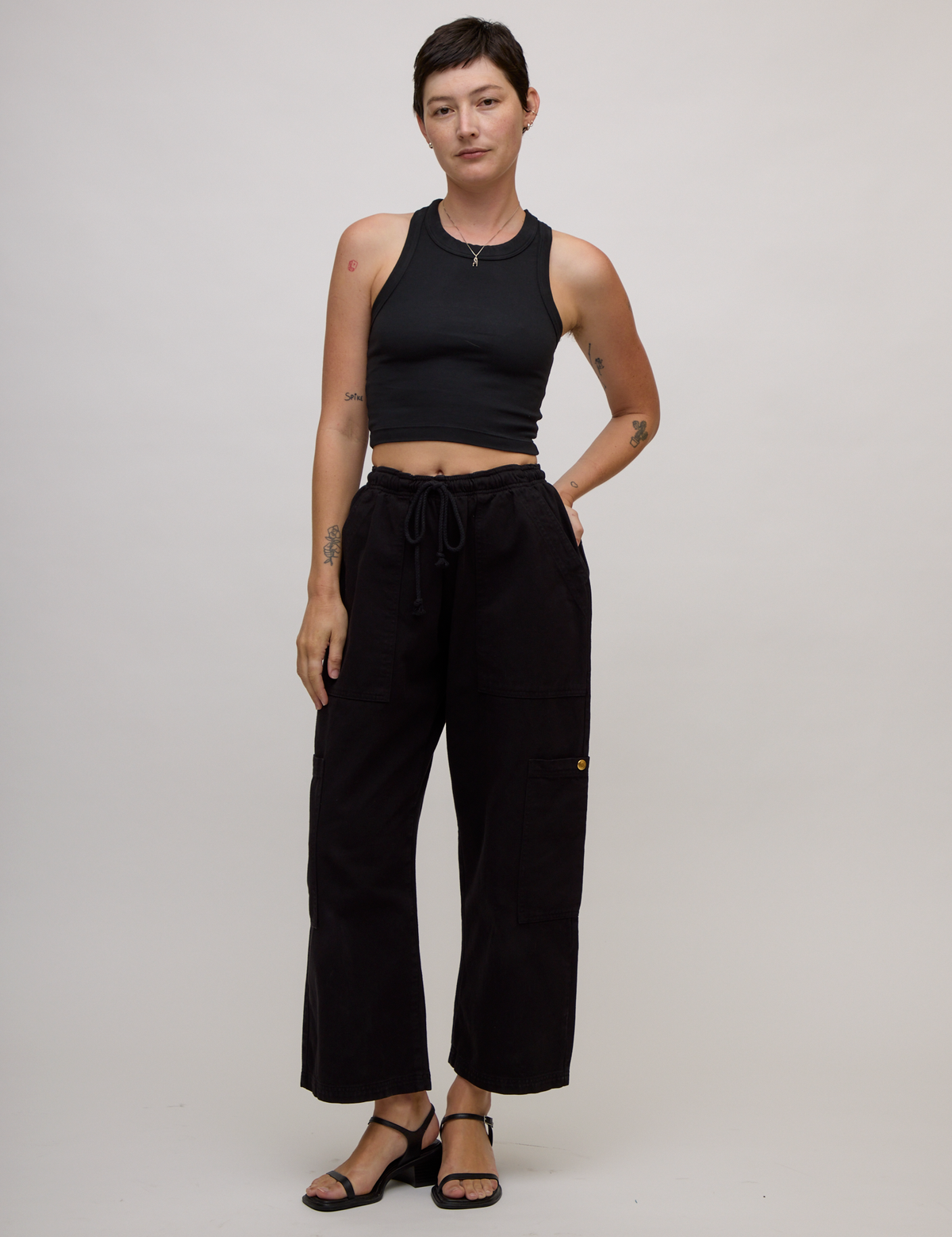 Alex is wearing the Basic Black Deep Cut Racerback with Black Drop Pocket Pants