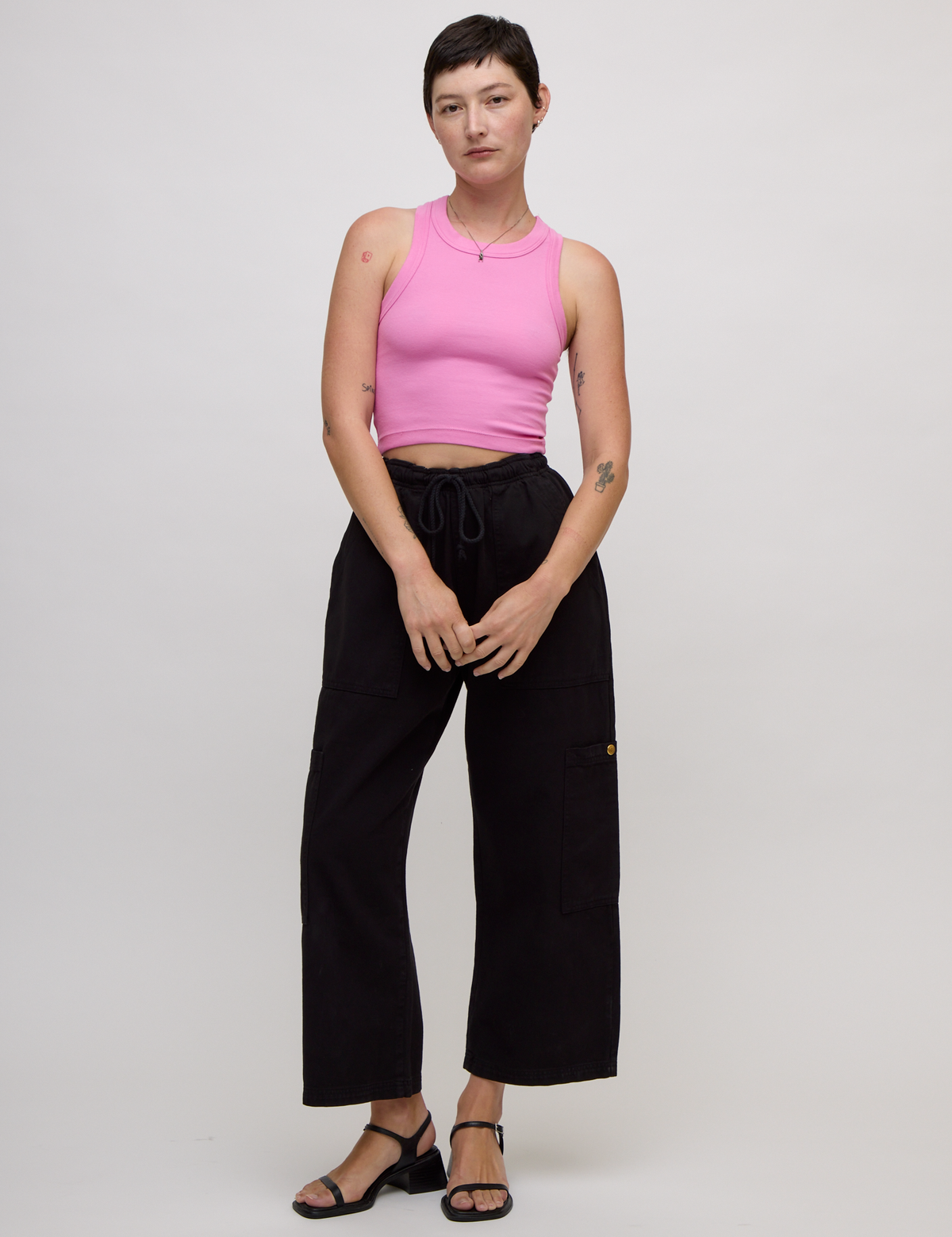 Alex is wearing the P Bubblegum Pink Deep Cut Racerback with Black Drop Pocket Pants