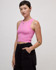 Angled side view of Alex wearing the P Bubblegum Pink Deep Cut Racerback
