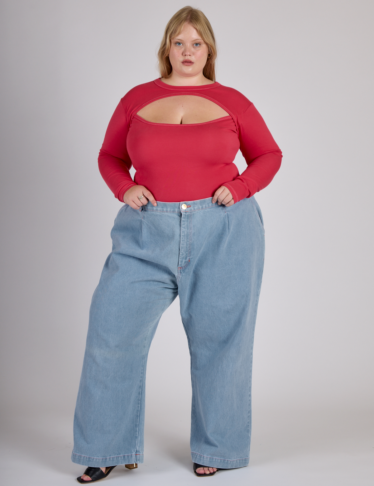 Juliet wearing the Hot Pink Long Sleeve Porthole Tee tucked into Light Wash Denim Wide Leg Trousers