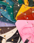 Overall Handbags in an rainbow of colors laid flat in a circular path