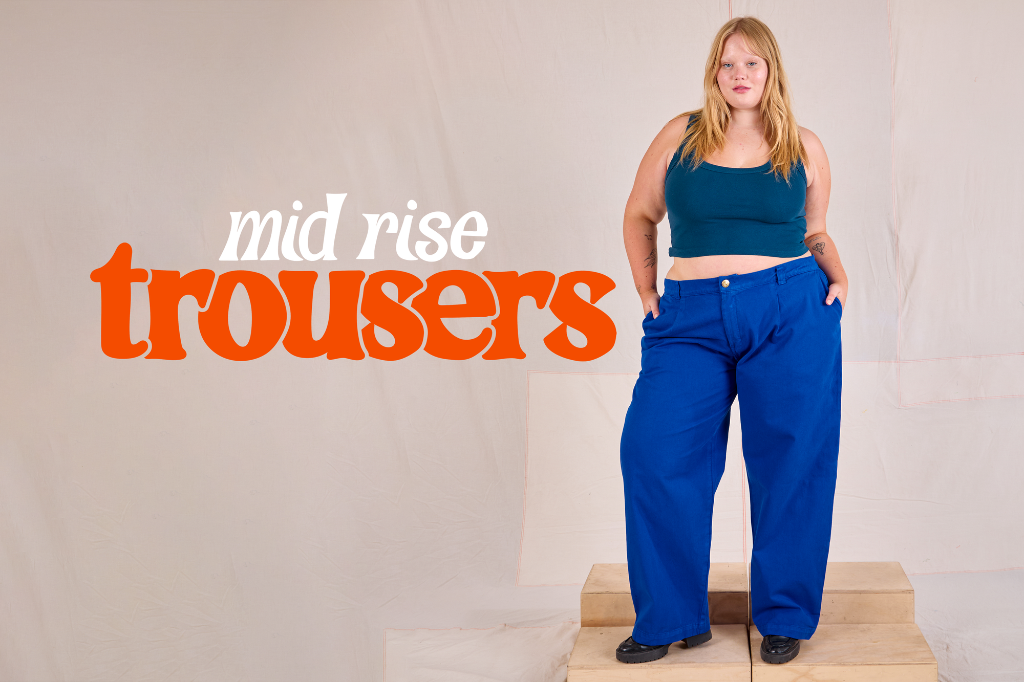 Juliet is wearing Mid Rise Pleated Trousers in Royal Blue paired with a marine blue Cropped Tank