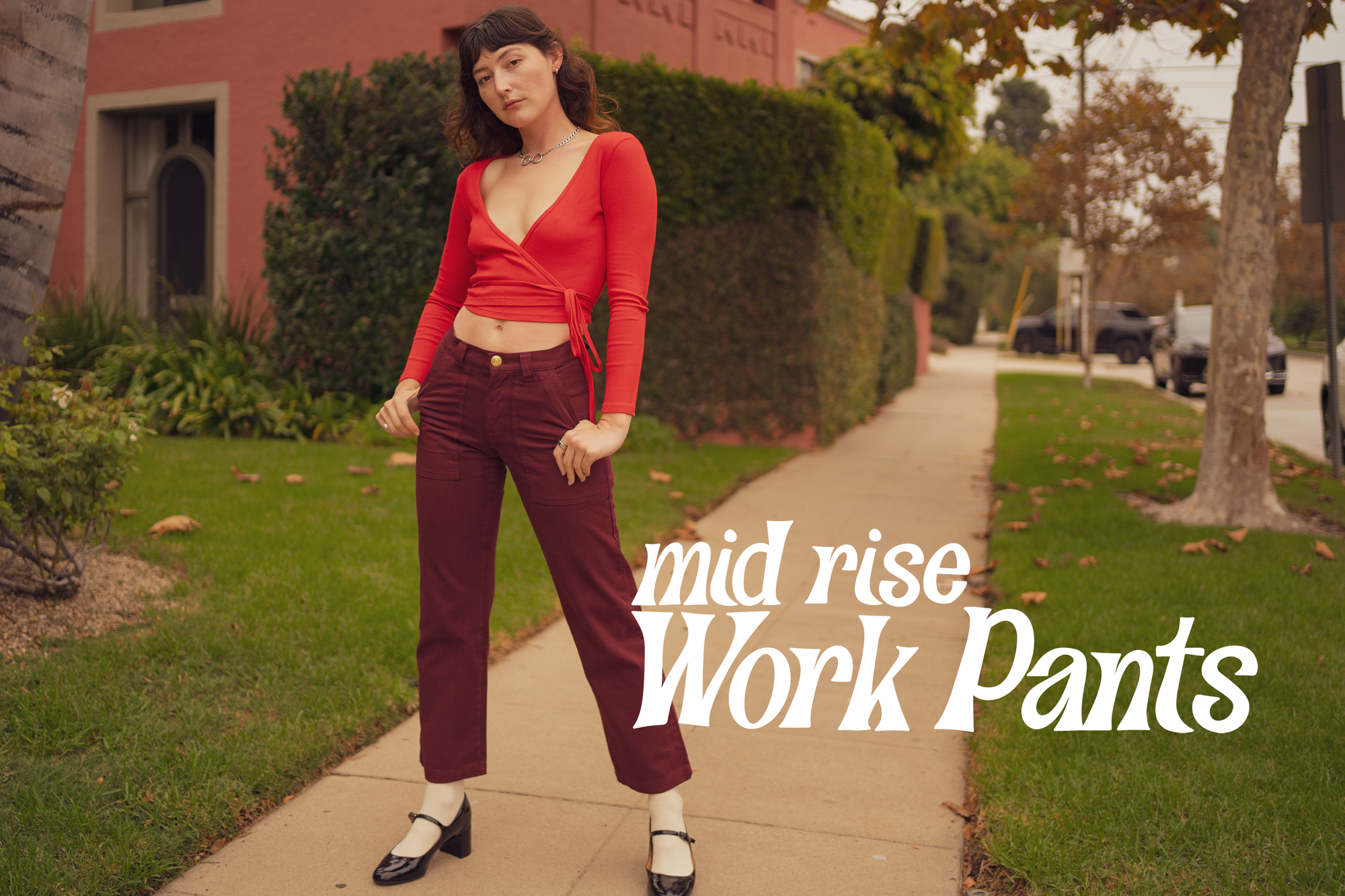 Alex is wearing Mid Rise Work Pants in Red Wine paired with a mustang red Wrap Top