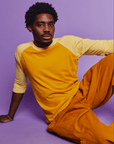 Isaac is 5'10" and wearing M Mustard Yellow/Butter Raglan Tee