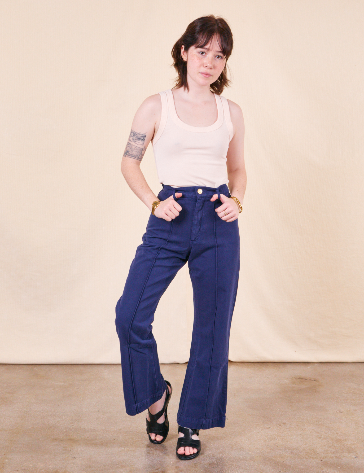 Hana is 5&#39;3&quot; and wearing XXS Petite Western Pants in Navy paired with a vintage off-white Tank Top