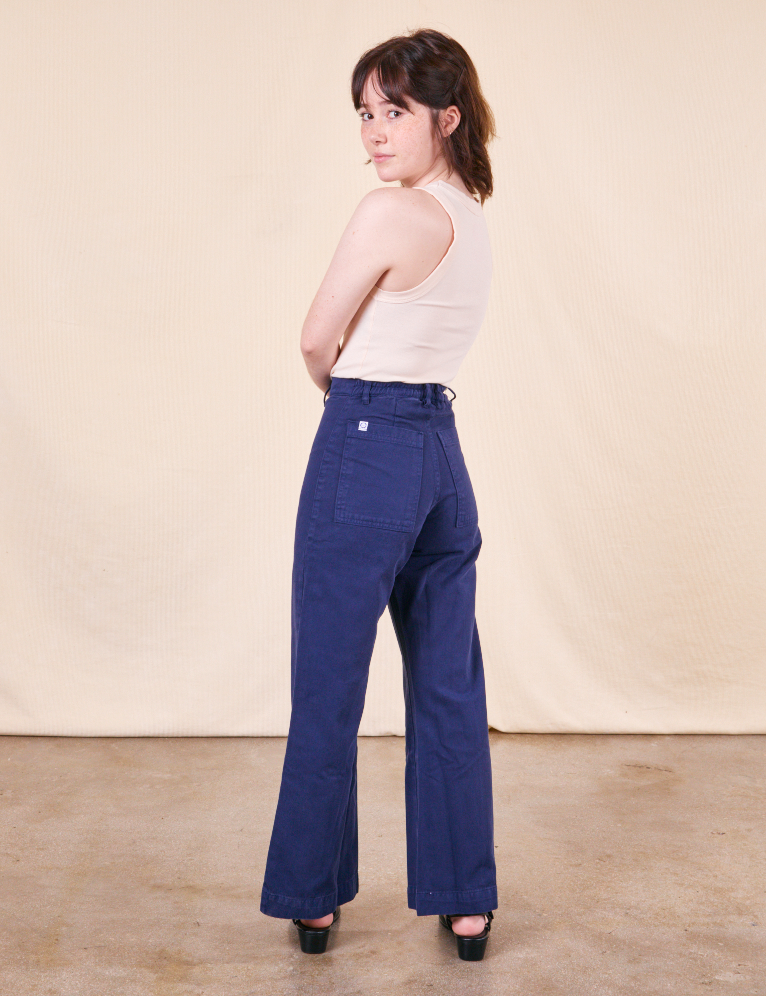 Back view of Western Pants in Navy paired with a vintage off-white Tank Top worn by Hana