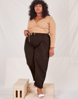 Morgan is 5'5" and wearing 1XL Heritage Trousers in Espresso Brown paired with tan Wrap Top