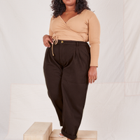 Morgan is 5'5" and wearing 1XL Heritage Trousers in Espresso Brown paired with tan Wrap Top