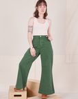 Hana is 5'3" and wearing XXS Bell Bottoms in Dark Emerald Green paired with vintage off-white Tank Top