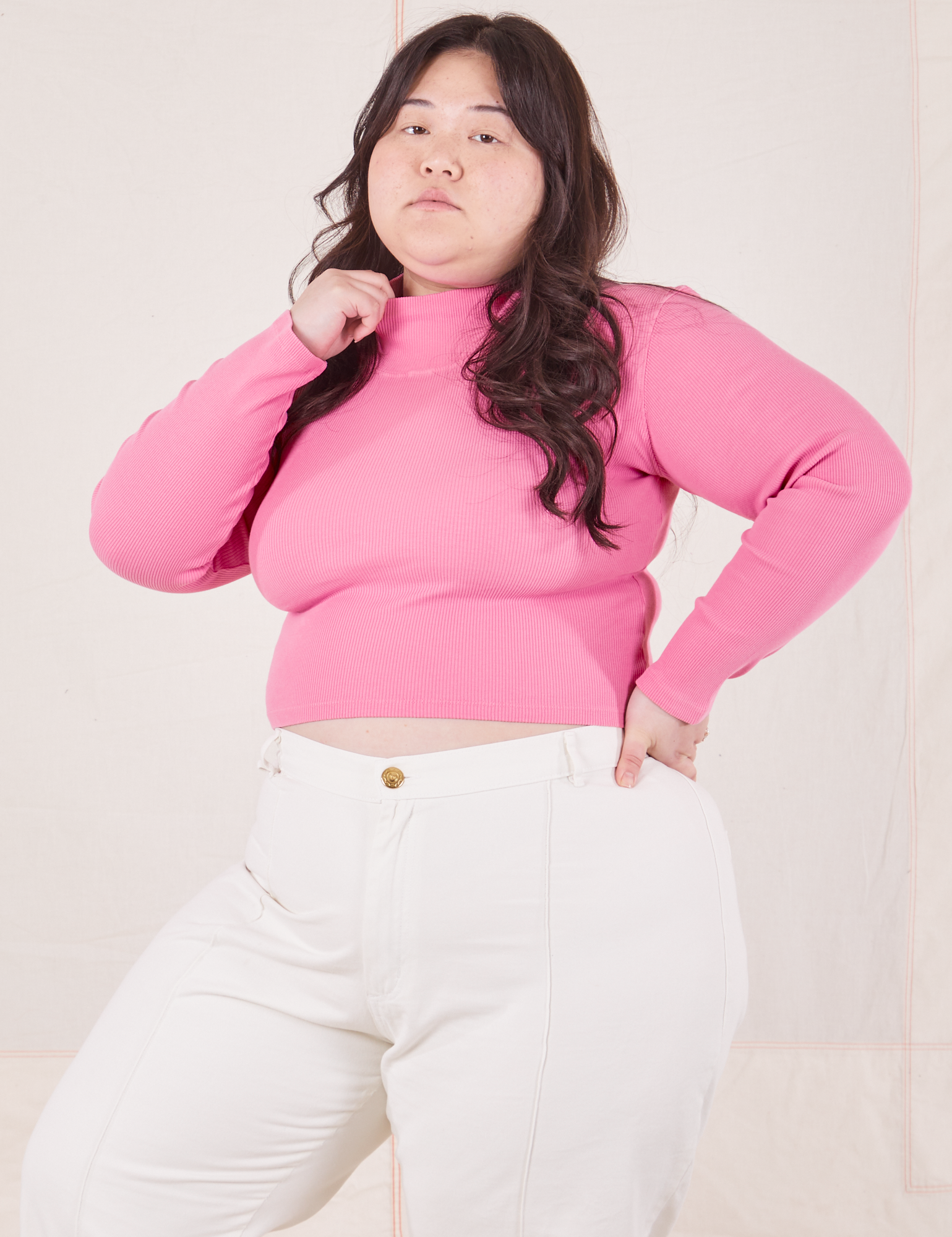 Ashley is wearing size L Essential Turtleneck in Bubblegum Pink paired with vintage off-white Western Pants