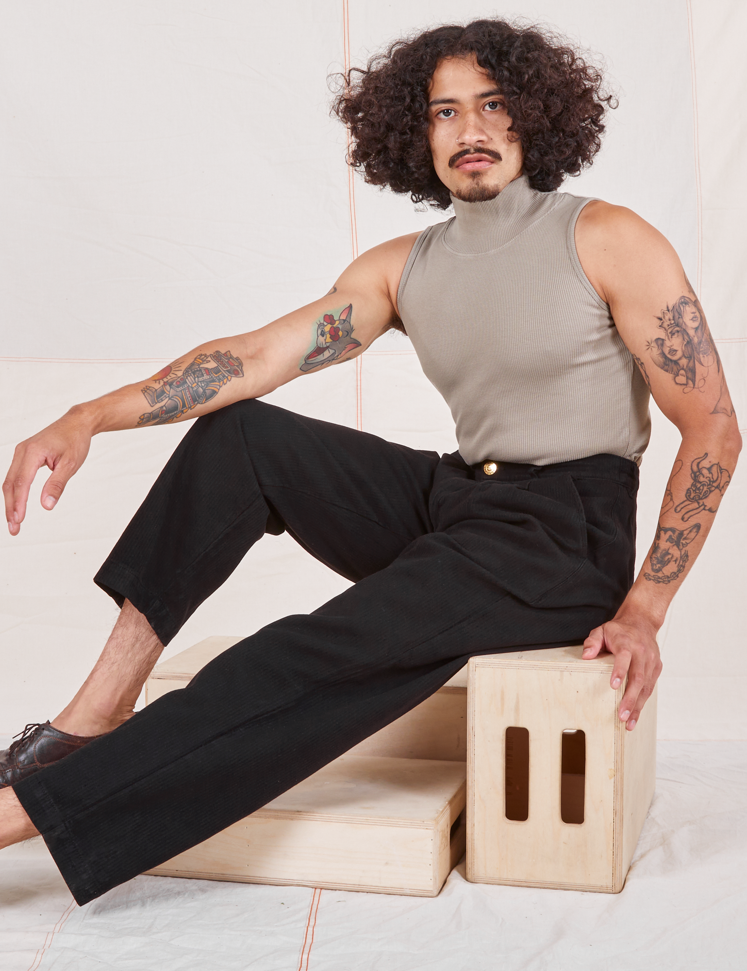 Jesse is 5&#39;8&quot; and wearing XS Heritage Trousers in Basic Black paired with khaki grey Sleeveless Turtleneck