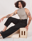 Jesse is 5'8" and wearing XS Heritage Trousers in Basic Black paired with khaki grey Sleeveless Turtleneck