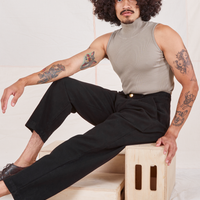 Jesse is 5'8" and wearing XS Heritage Trousers in Basic Black paired with khaki grey Sleeveless Turtleneck