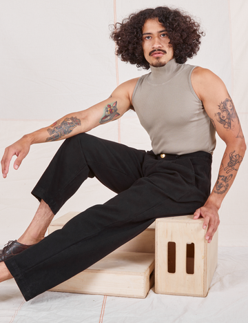 Jesse is 5'8" and wearing XS Heritage Trousers in Basic Black paired with khaki grey Sleeveless Turtleneck