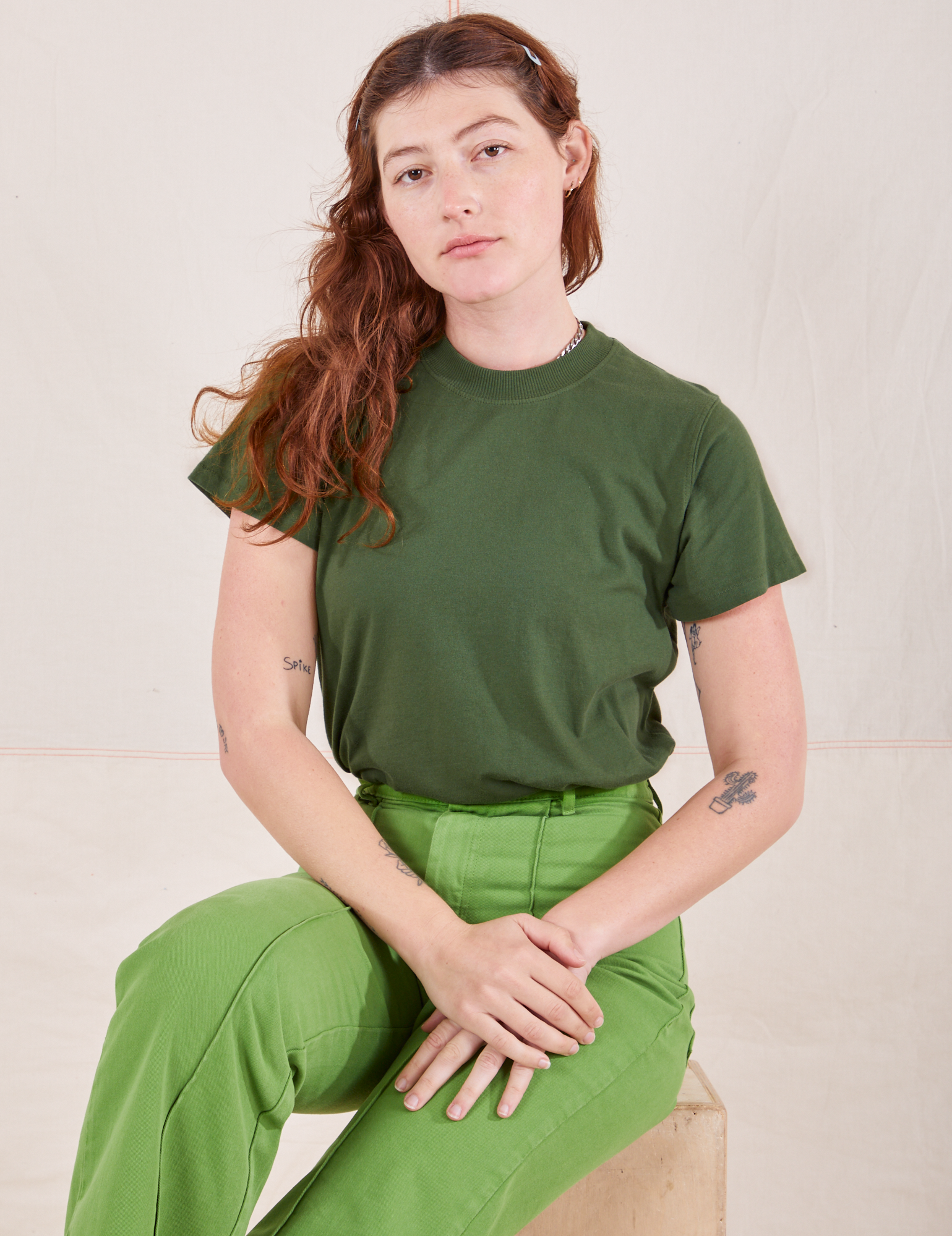 Alex is wearing P Organic Vintage Tee in Dark Emerald Green paired with gross green Western Pants
