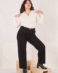 Melanie is 5'6" and wearing M Organic Work Pants in Basic Black paired with vintage off-white Long Sleeve Fisherman Polo