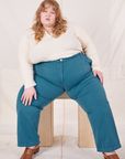 Catie is wearing Organic Work Pants in Marine Blue and vintage off-white Long Sleeve Fisherman Polo