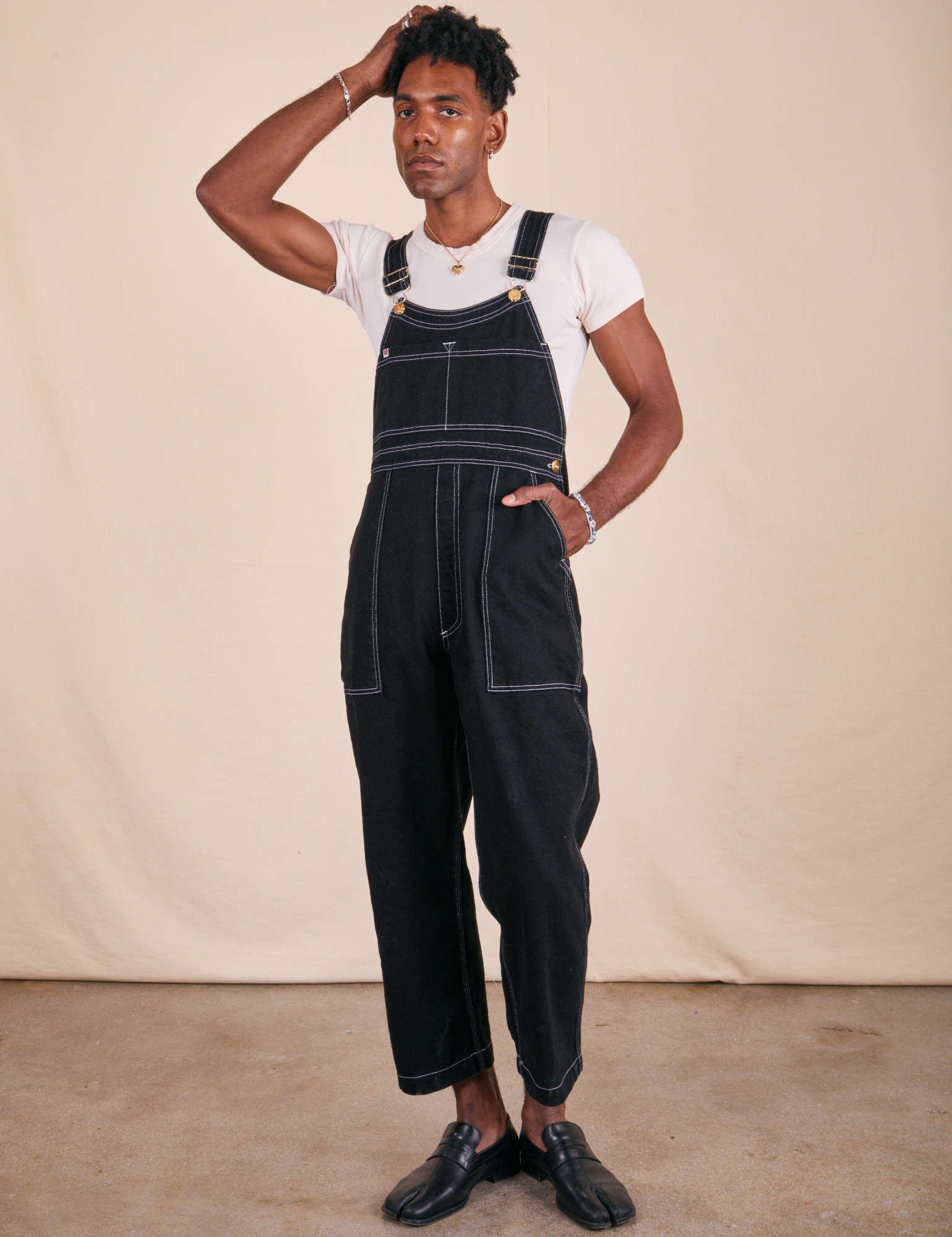 Jerrod is 6&#39;3&quot; and wearing M Original Overalls in Basic Black paired with vintage off-white Baby Tee