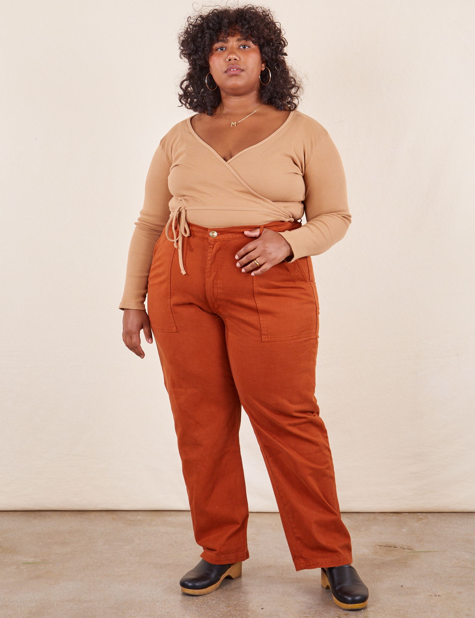 Morgan is 5'5" and wearing 3XL Work Pants in Burnt Terracotta paired with tan Wrap Top