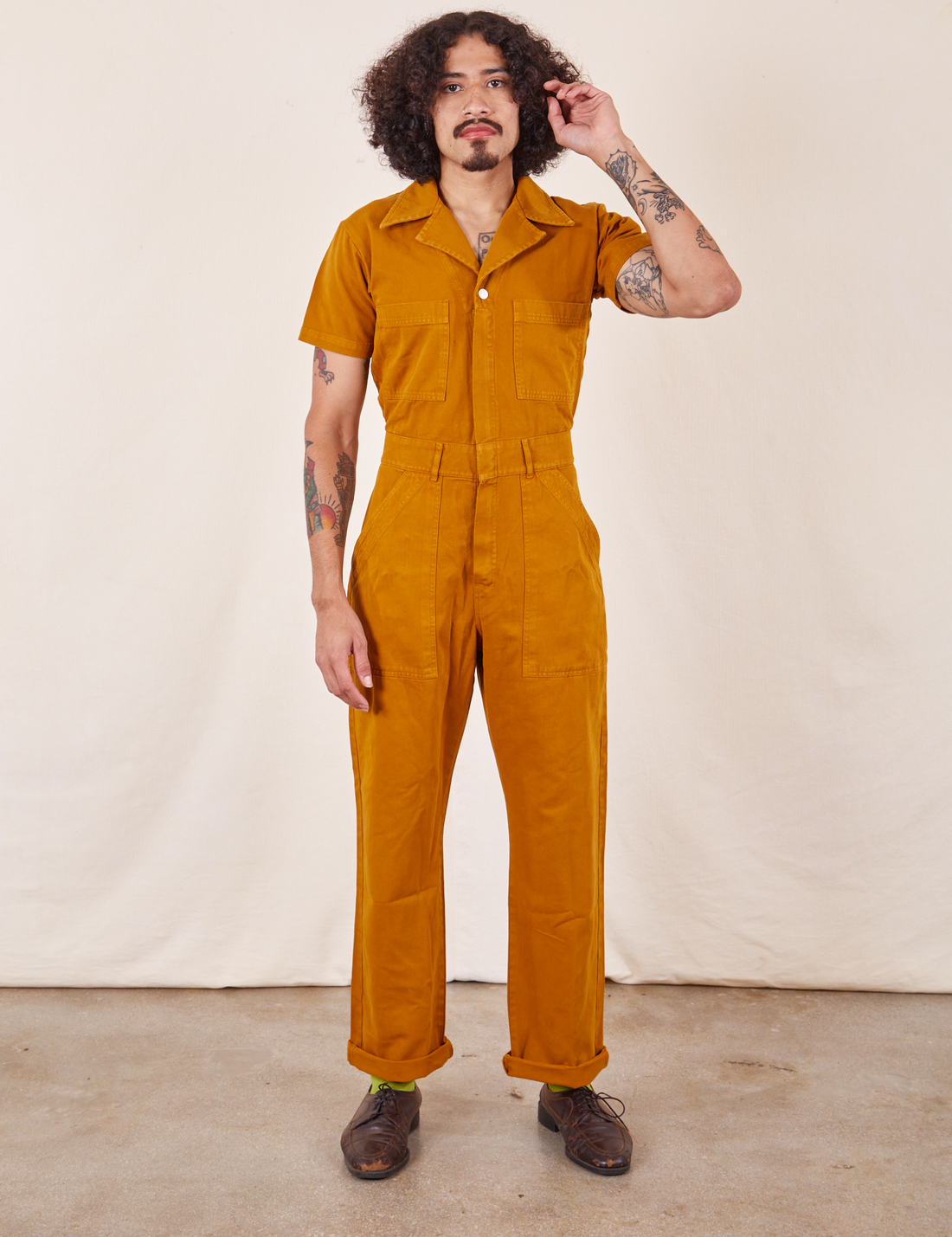 Jesse is 5'7" and wearing S Short Sleeve Jumpsuit in Spicy Mustard