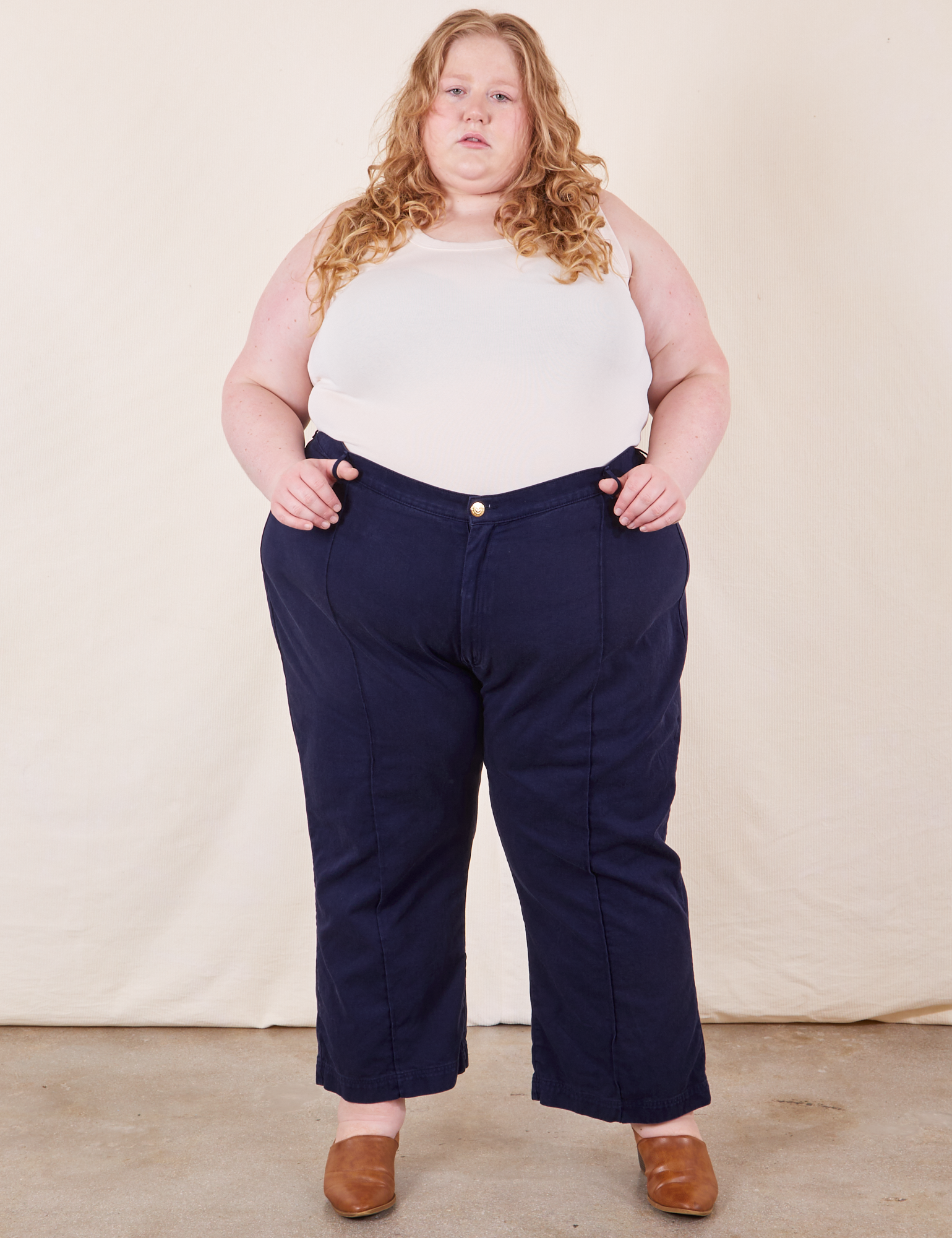 Catie is 5'11" and wearing 5XL Western Pants in Navy Blue paired with vintage off-white Tank Top