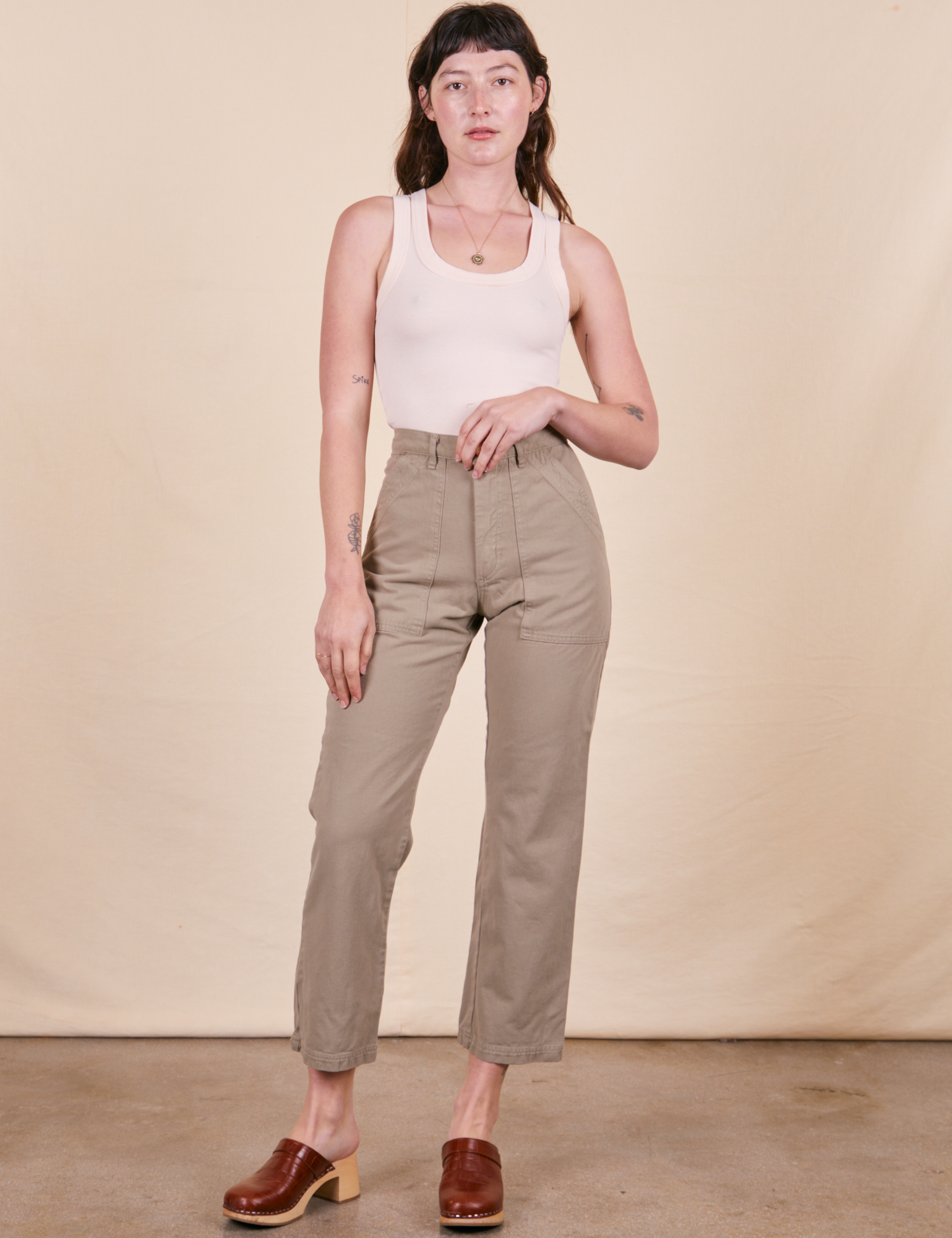 Alex is 5&#39;8&quot; and wearing XS Work Pants in Khaki Grey paired with vintage off-white Tank Top
