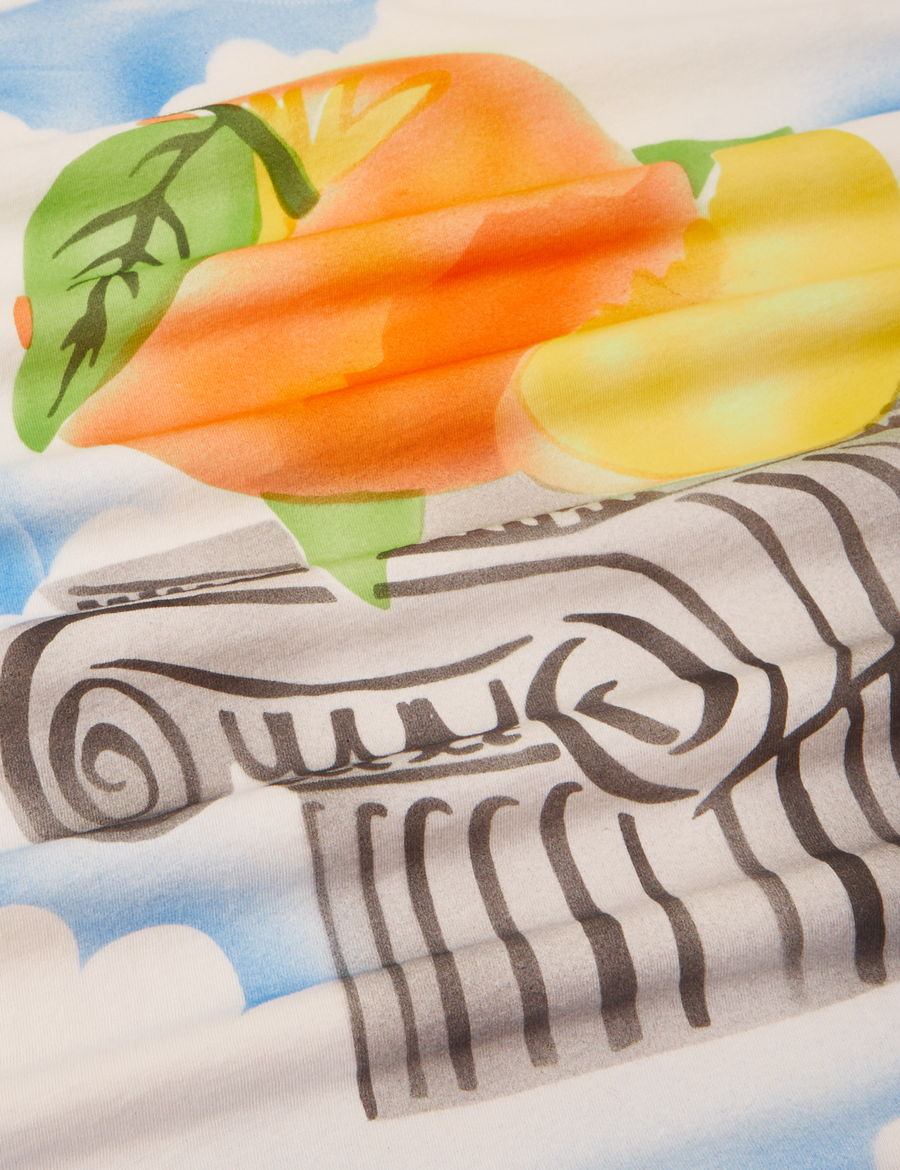 Peach Airbrush Organic Tee close up airbrushed peaches on column with clouds in the background