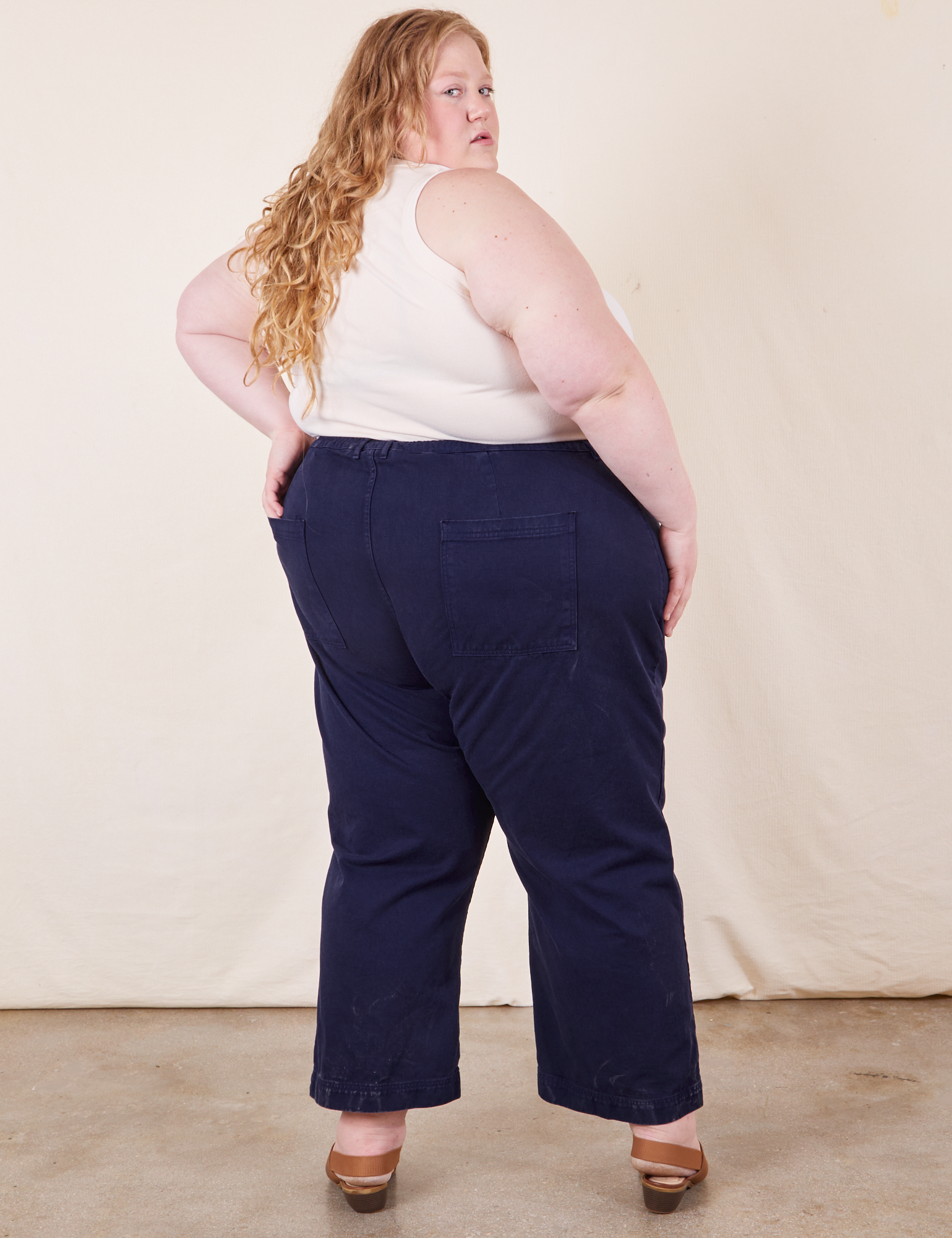 Back view of Western Pants in Navy Blue and vintage off-white Tank Top on Catie