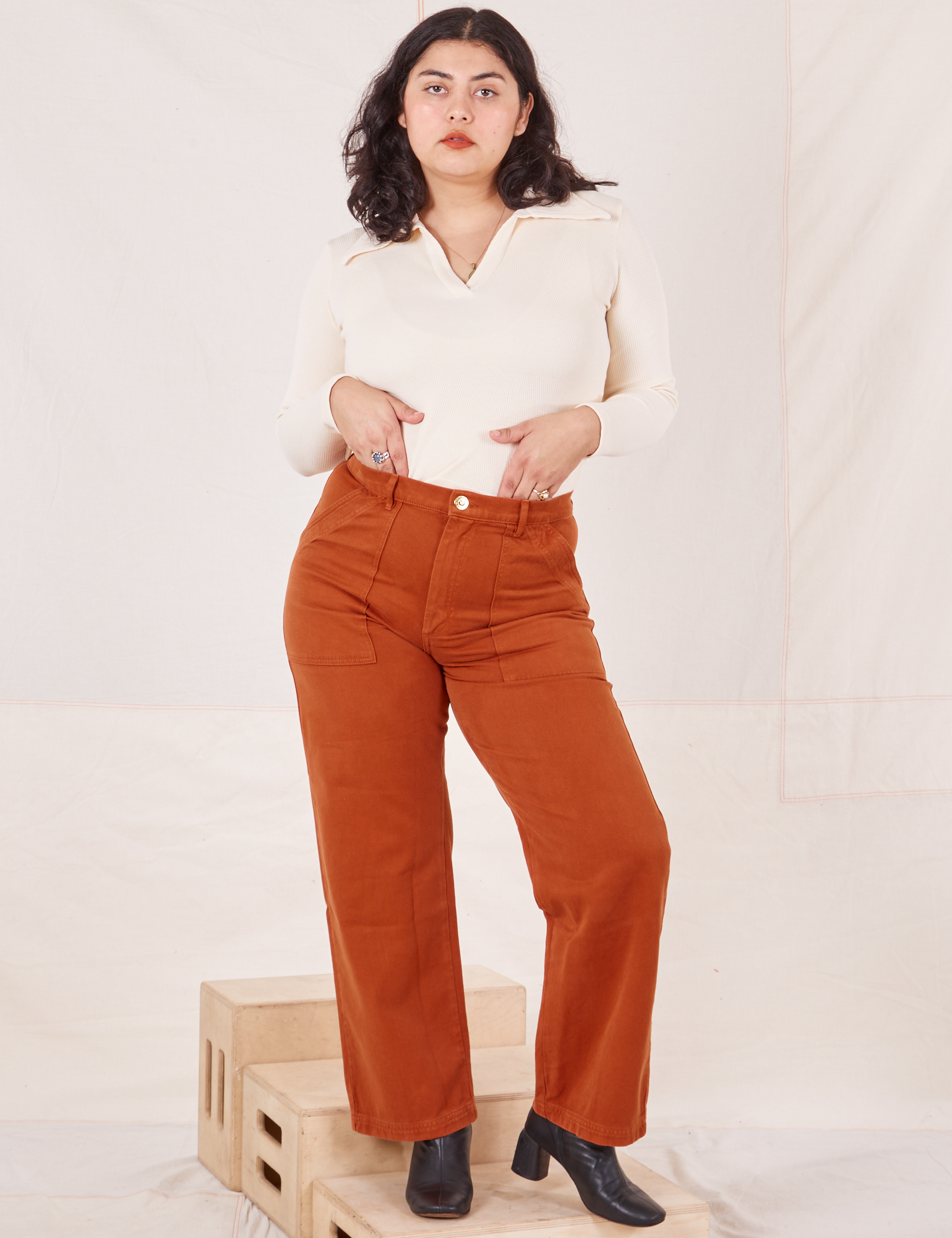 Melanie is 5&#39;6&quot; and wearing M Organic Work Pants in Burnt Terracotta paired with vintage off-white Long Sleeve Fisherman Polo