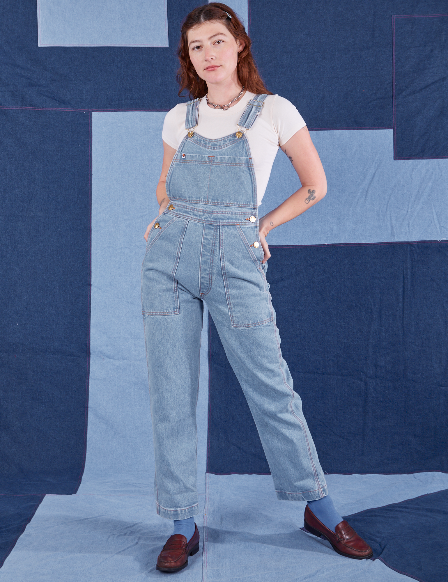 Alex is wearing Indigo Denim Original Overalls in Light Wash and vintage off-white Baby Tee