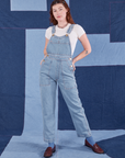 Alex is wearing Indigo Denim Original Overalls in Light Wash and vintage off-white Baby Tee