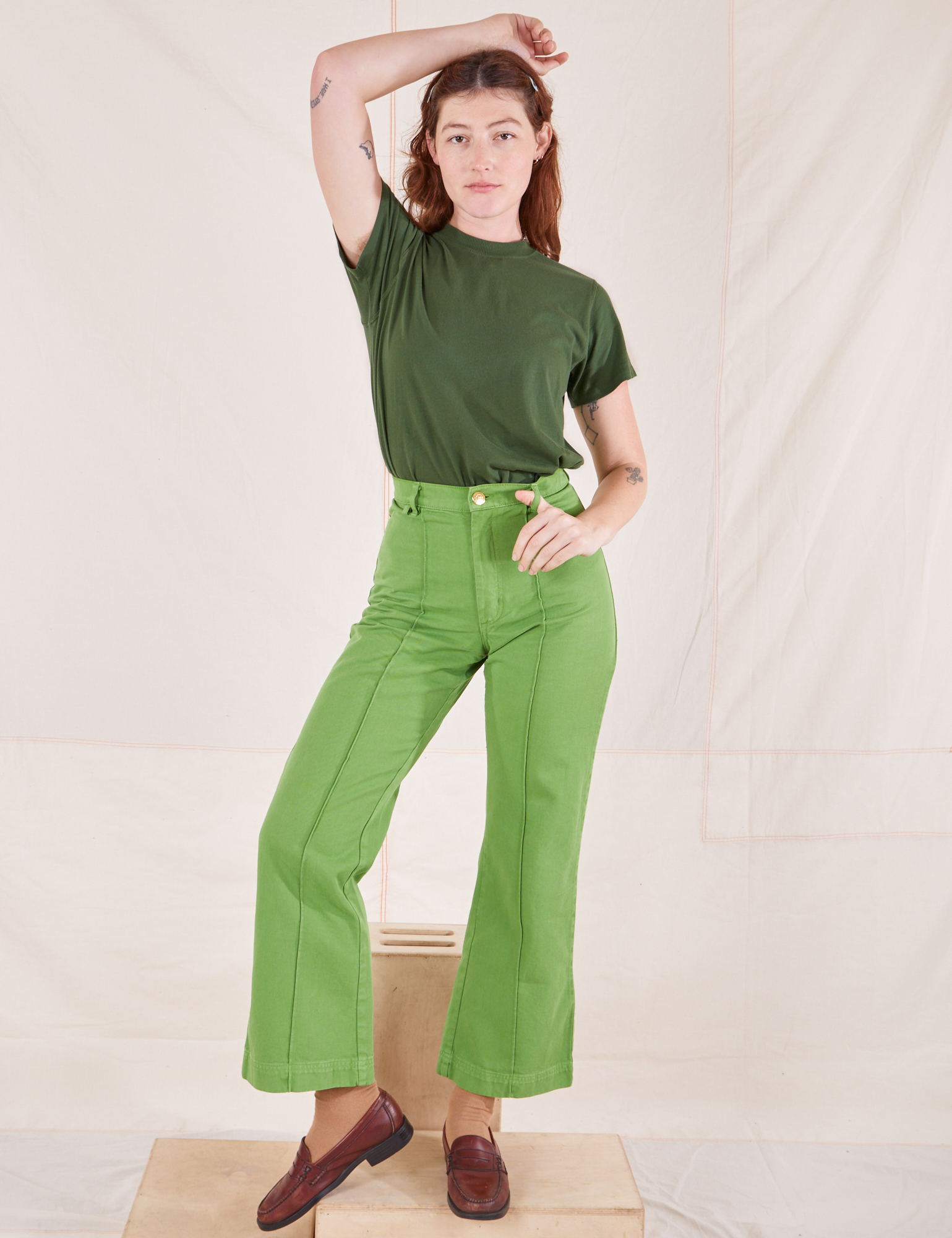 Alex is wearing Organic Vintage Tee in Dark Emerald Green and gross green Western Pants