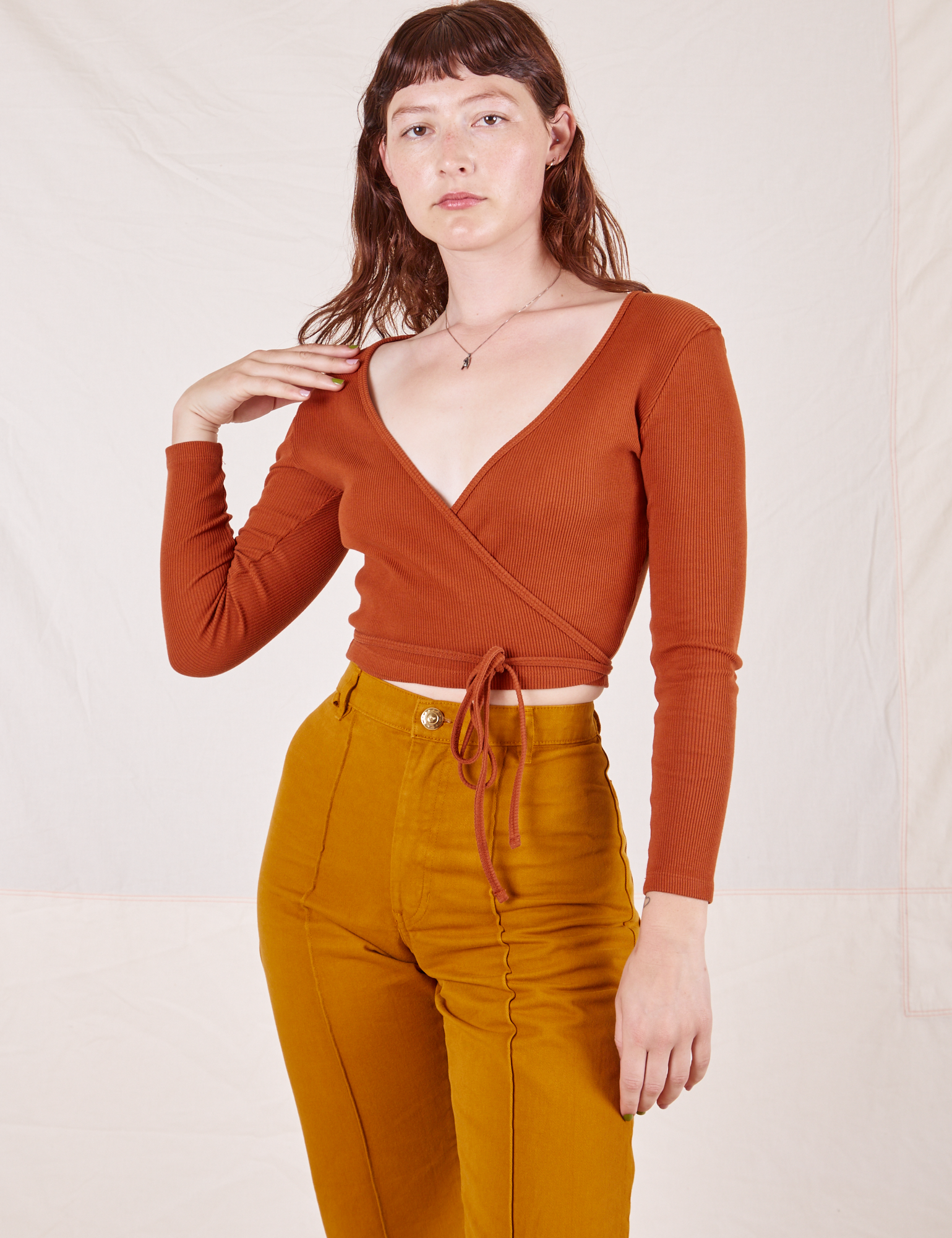 Alex is wearing size 1 Wrap Top in Burnt Terracotta paired with spicy mustard Western Pants