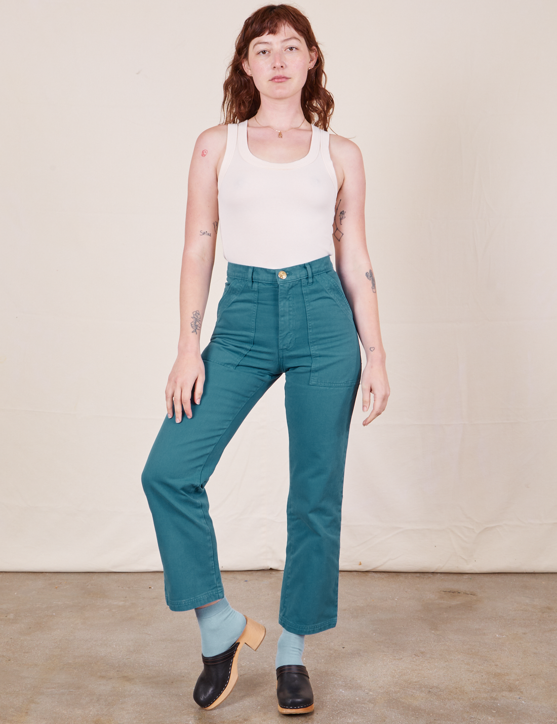 Alex is 5'8" and wearing size XS Work Pants in Marine Blue paired with vintage off-white Tank Top