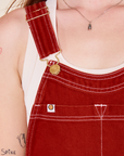 Original Overalls in Paprika front close up of white stitching and gold hardware on Alex