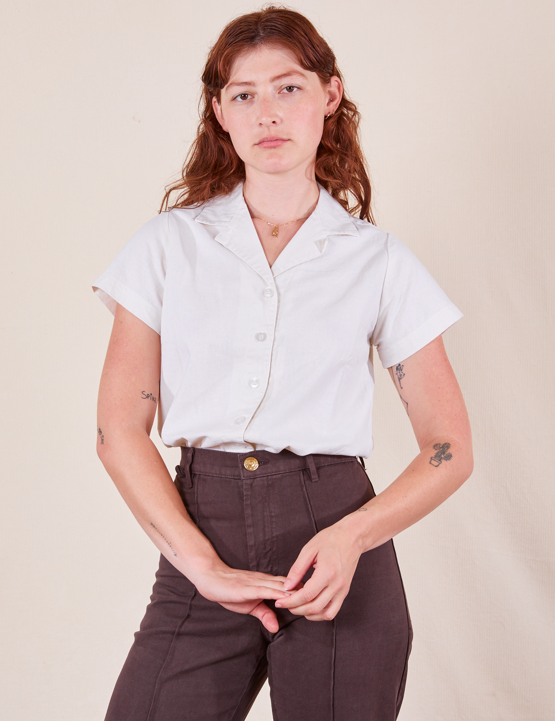 Alex is wearing Pantry Button-Up in Vintage Tee White tucked into espresso brown Western Pants