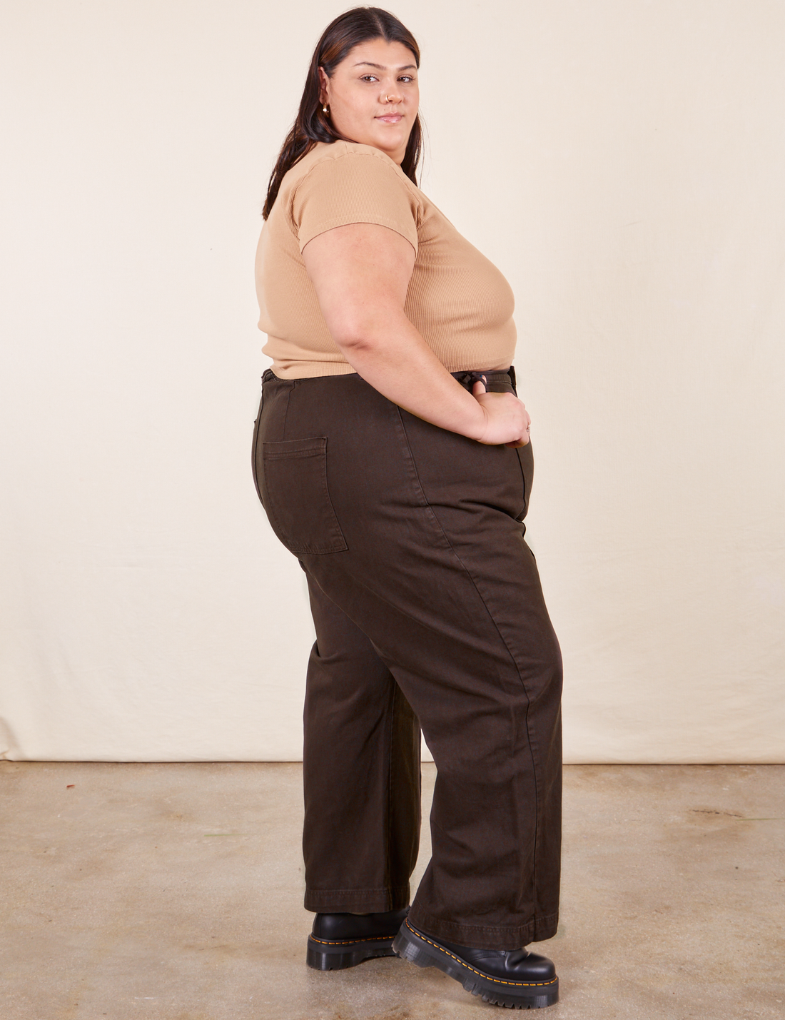 Side view of Western Pants in Espresso Brown paired with tan V-Neck Tee worn by Sarita