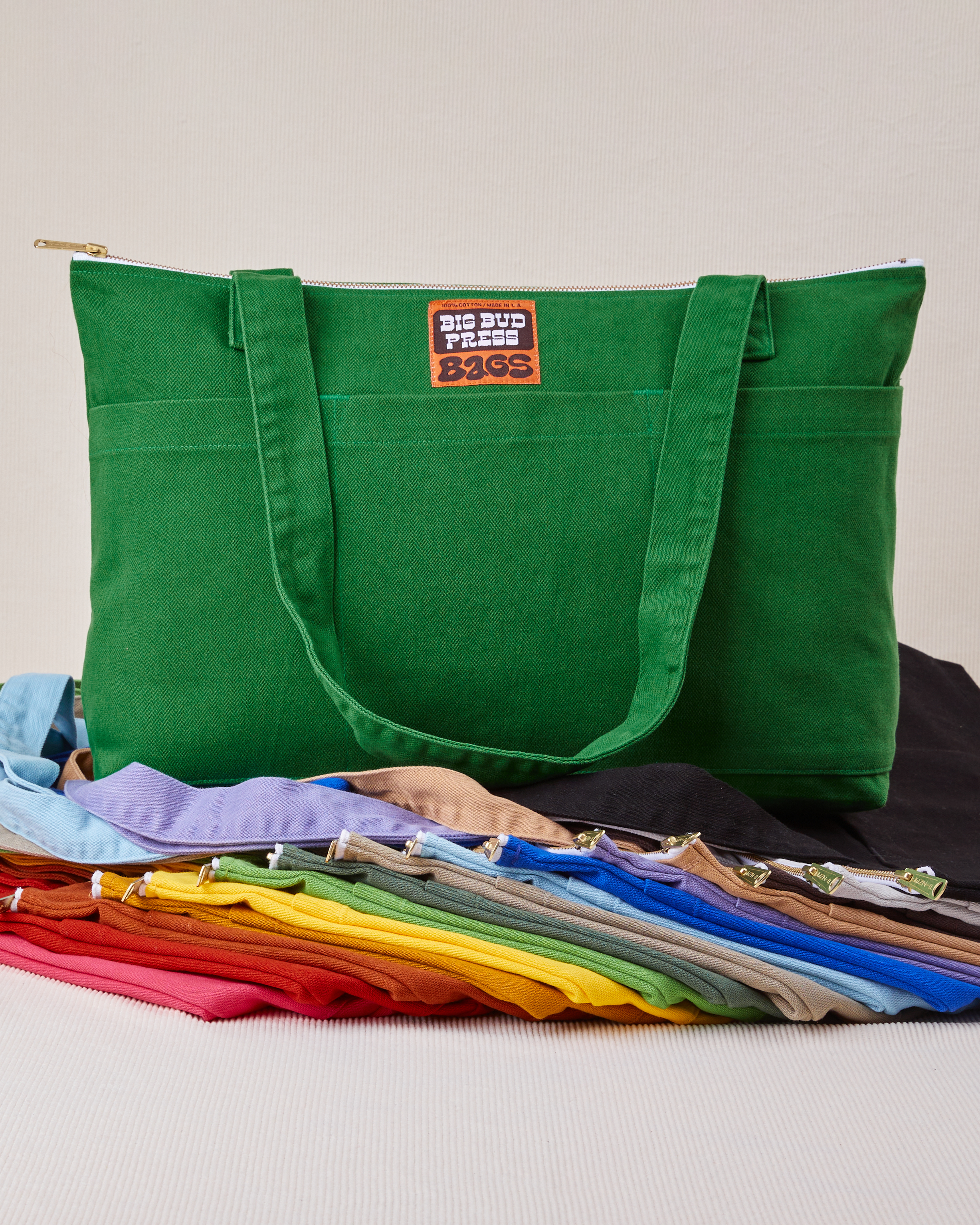 XL Zip Tote in forest green sitting on top of other colors laid flat
