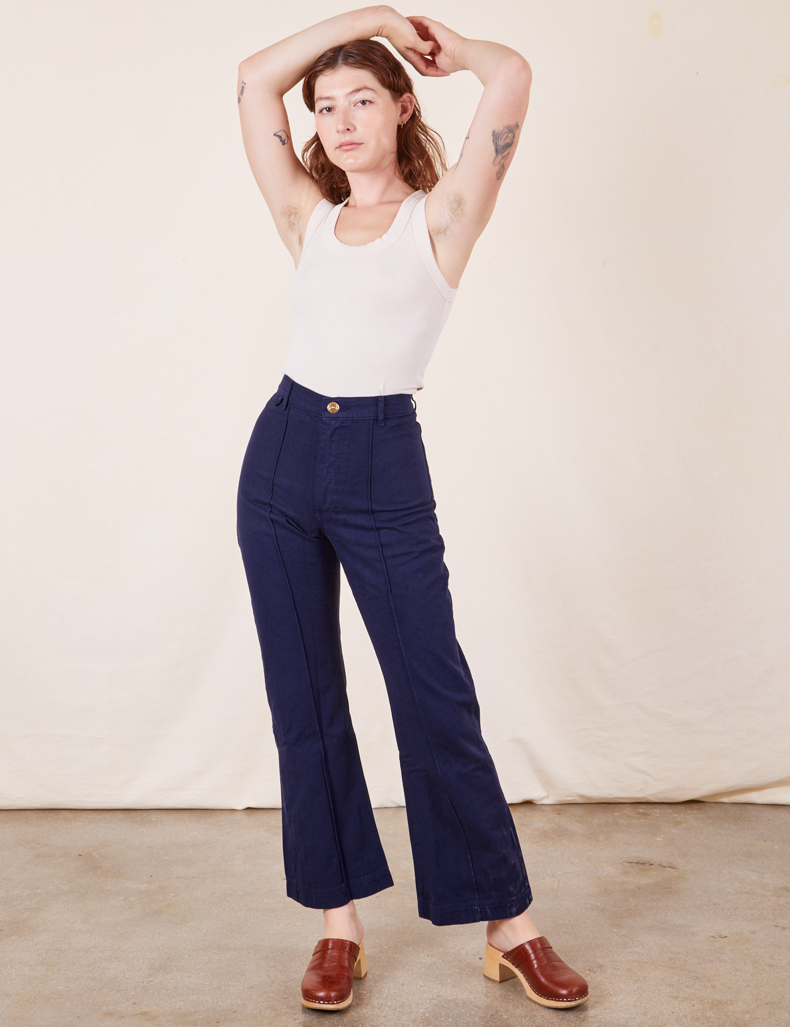 Alex is 5&#39;8&quot; and wearing XS Western Pants in Navy Blue paired with vintage off-white Tank Top