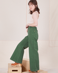 Side view of Bell Bottoms in Dark Emerald Green and vintage off-white Tank Top worn by Hana
