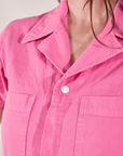 Short Sleeve Jumpsuit in Bubblegum Pink front close up on Allison. Collar, two pockets and white sun baby snap