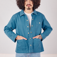 Jesse is wearing Denim Work Jacket in Marine Blue. They have both hands in the front pocket.